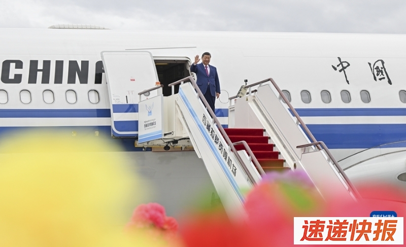 这是习近平走出舱门，向欢迎群众挥手致意。